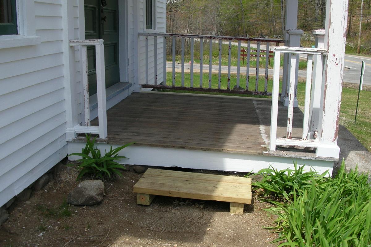 A wooden step replaces the dilapidated ramp that was removed last Fall.  A new accessible entrance will be installed later, as the rehab progresses.