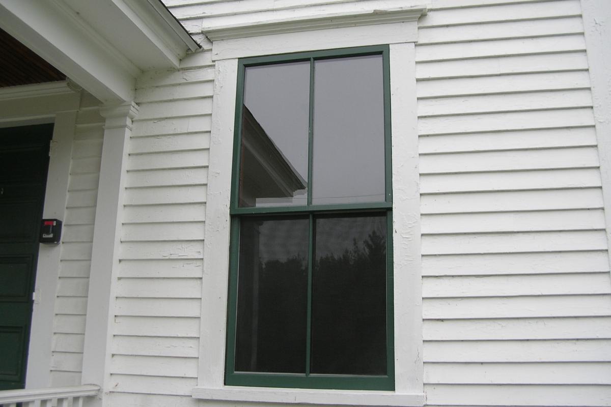 After Photo:  Repaired and refurbished front window with new, nearly invisible storm window at upper sash and window screen below.