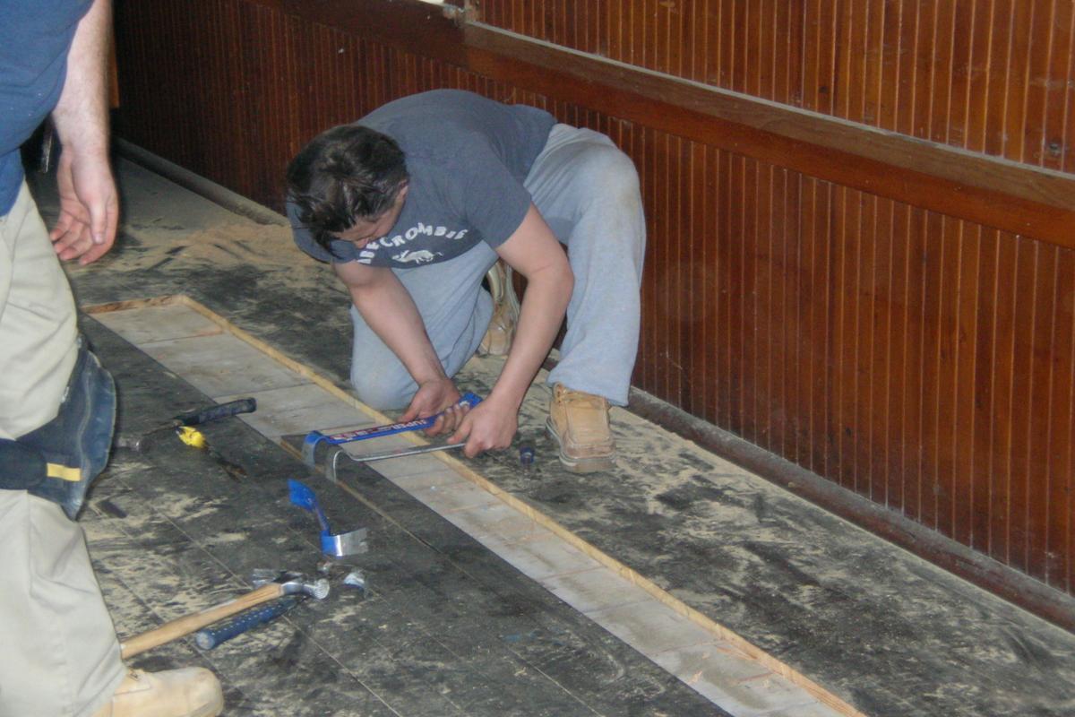 Skilled restoration carpenters carefully remove some floorboards and sub-flooring, which will be saved on site and reinstalled in the Fall.